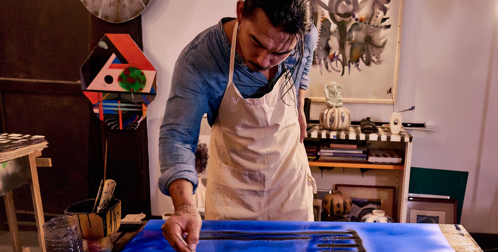 Artist painting while wearing a Wiseguy Original apron