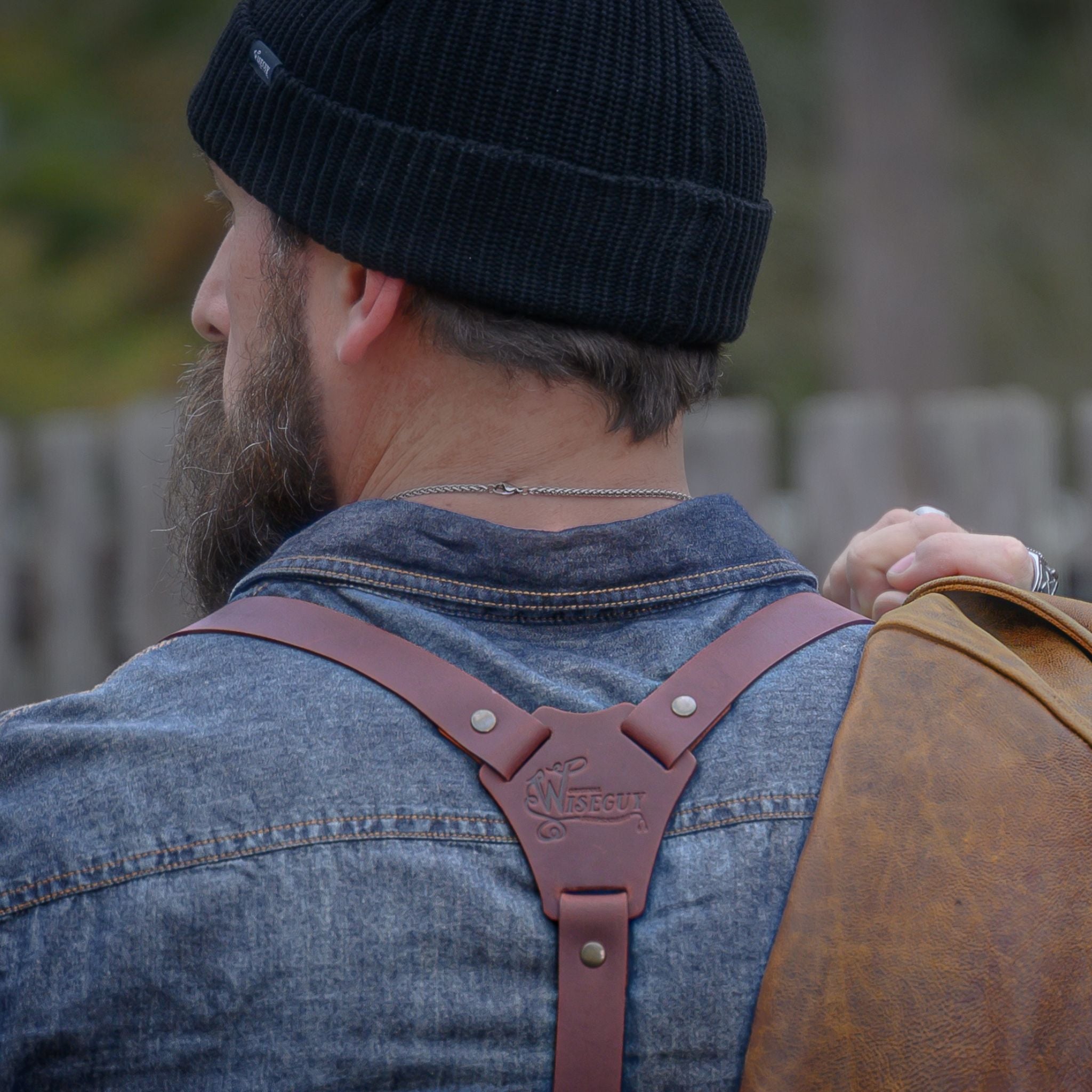 Man's back, wearing Wiseguy Original Suspenders on top of a denim shirt, he is wearing a beanie