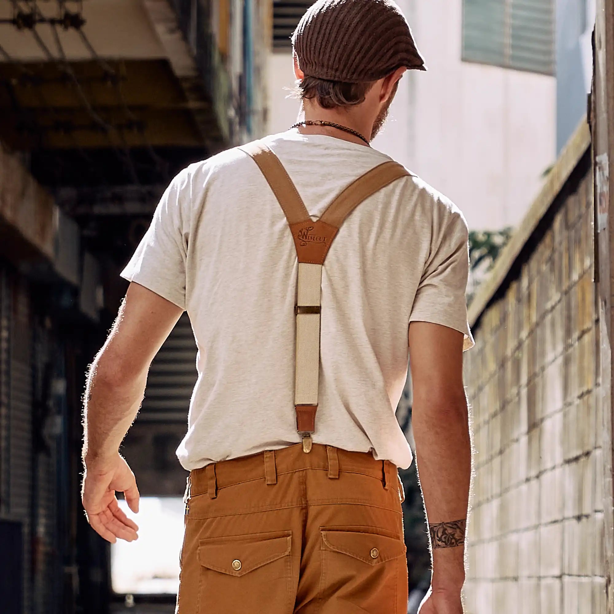 Man walking through streets wearing a flat cap and Wiseguy Original Suspenders